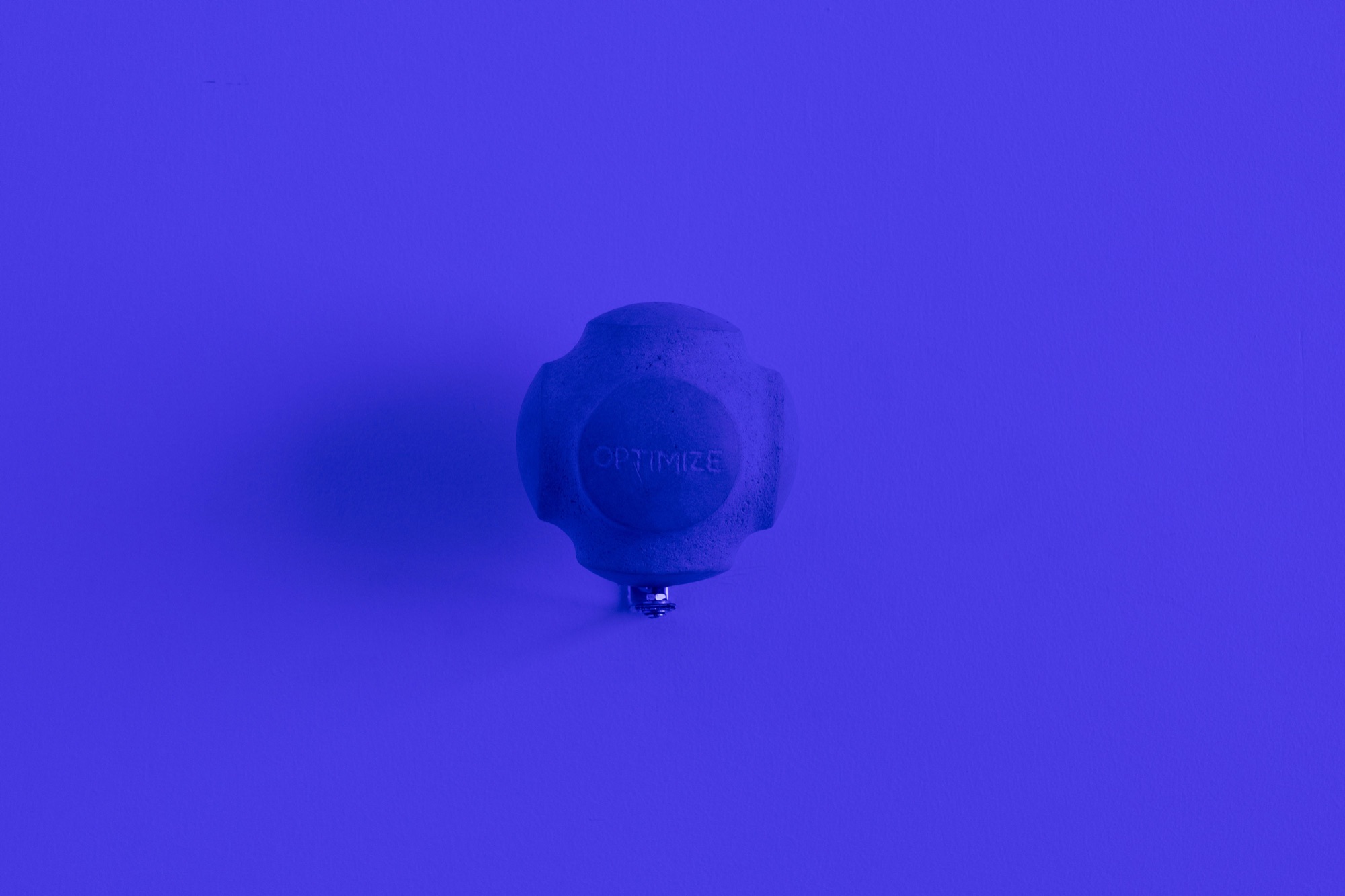 A small spherical object mounted on a blue wall